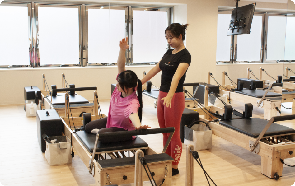 ピラティス体験している女性生徒と女性インストラクター
